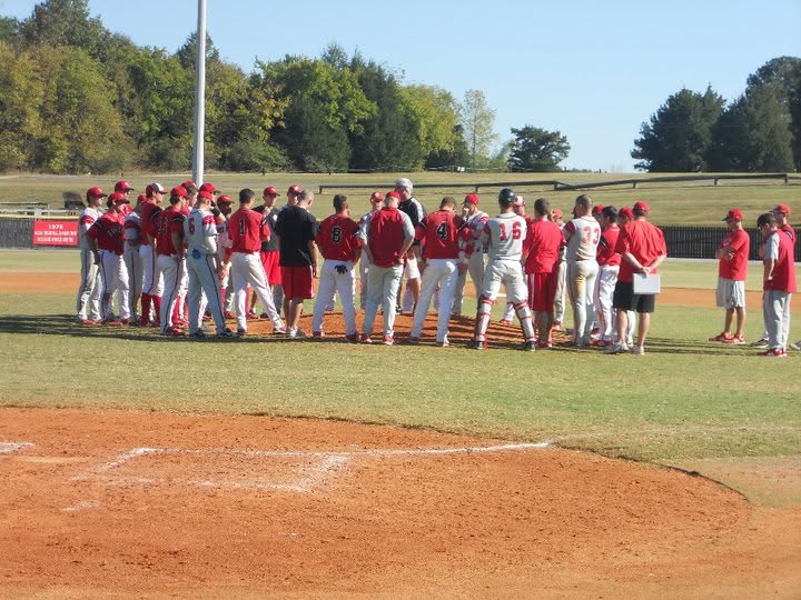 Chris's college baseball team huddled on the field
